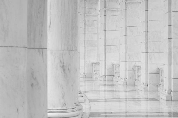 minimalist photography of hallway between columns